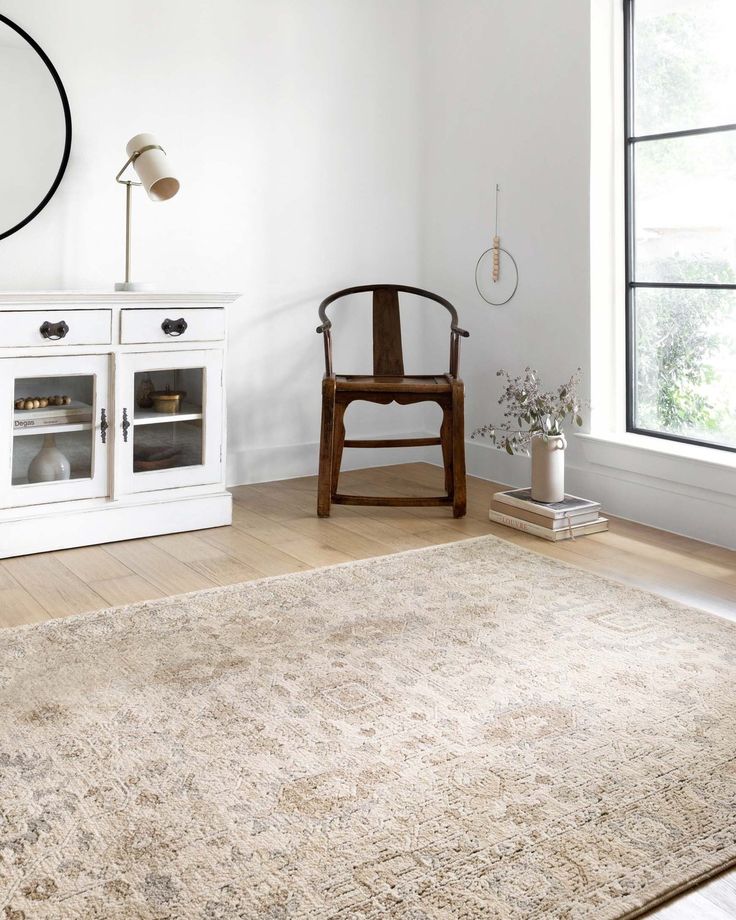 a room with a chair, rug and window