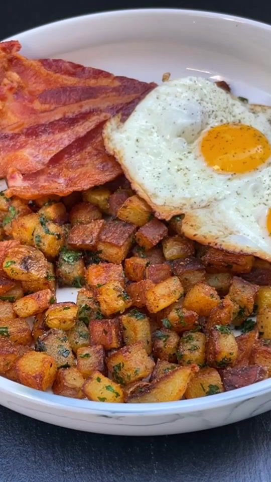 bacon, eggs and hash browns in a white bowl