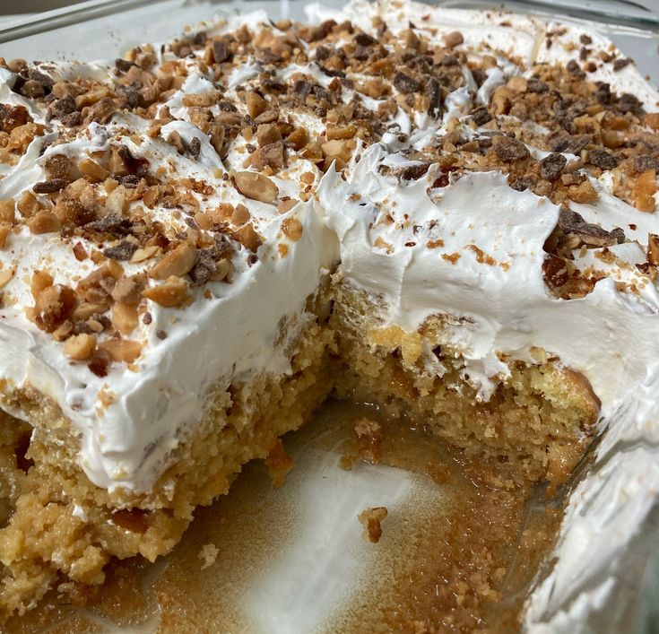 a cake with white frosting and nuts on top