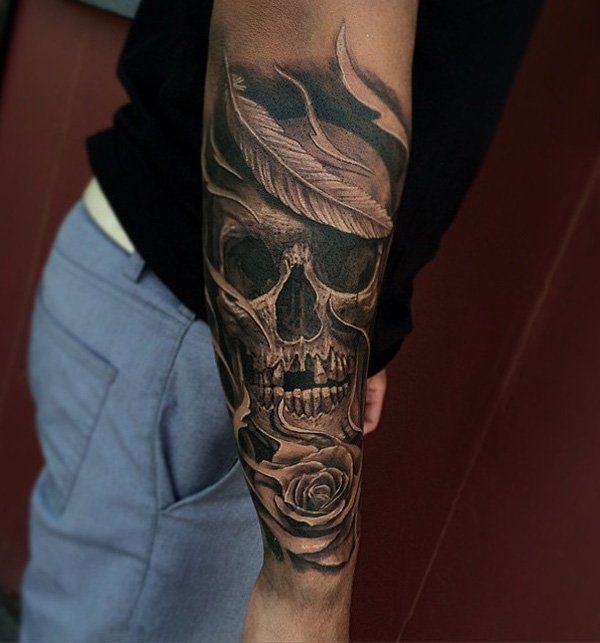 a man with a skull and rose tattoo on his arm