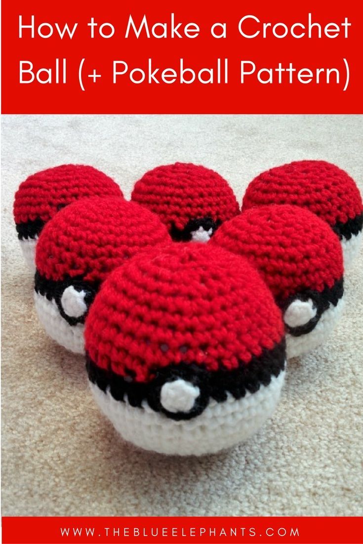 crocheted red and white balls with black eyes on them sitting on the floor