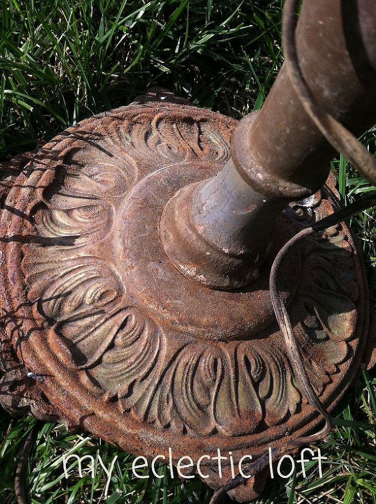 an old rusted metal object sitting in the middle of some grass with a wire attached to it