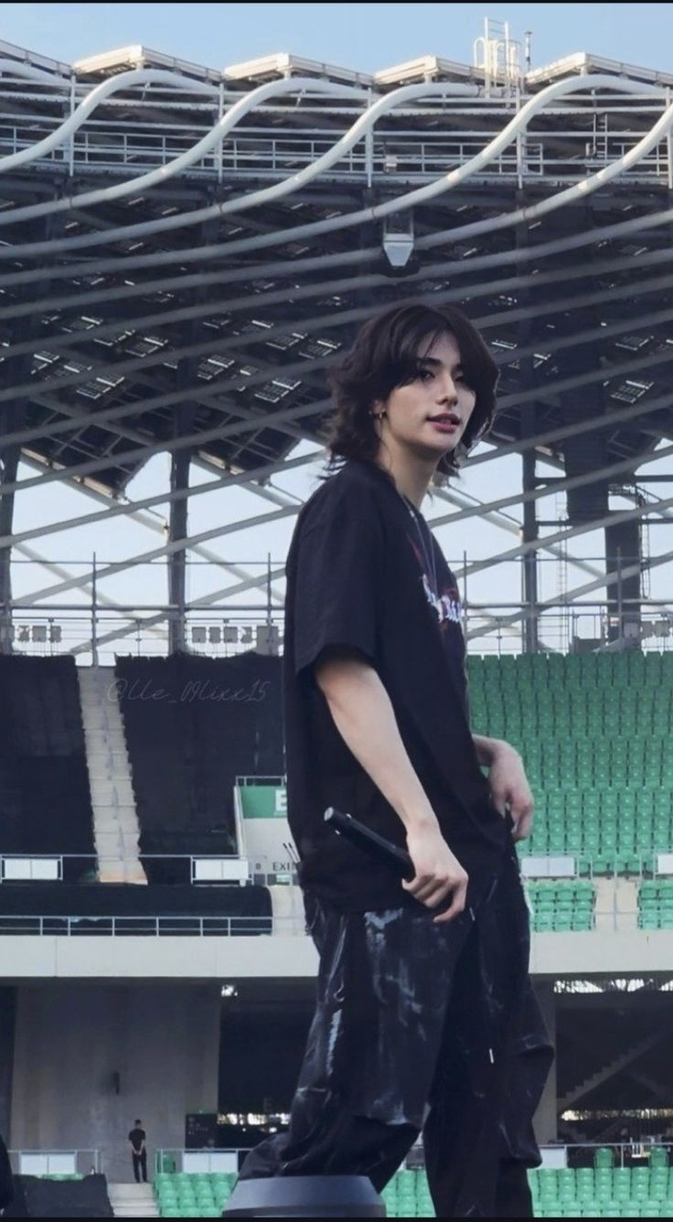 a man standing on top of a skateboard in front of an empty bleachers