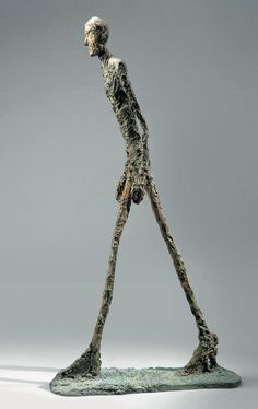 a sculpture of a human being walking