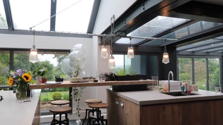 a kitchen with lots of counter space and lights hanging from the ceiling over the island