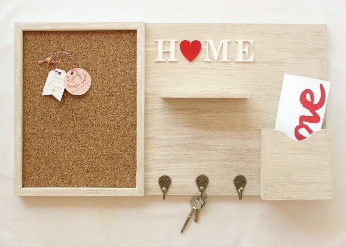 a cork board with magnets, keys and a heart on it that says home