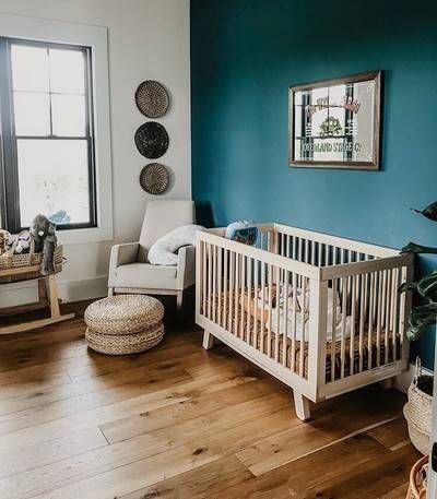 a baby's room with blue walls and wooden floors is pictured in this image