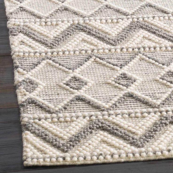 a white and gray rug on top of a wooden floor