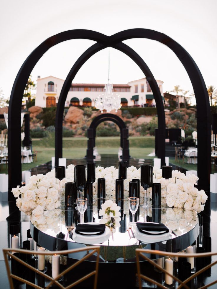 the table is set up with wine glasses and flowers on it for an elegant wedding reception