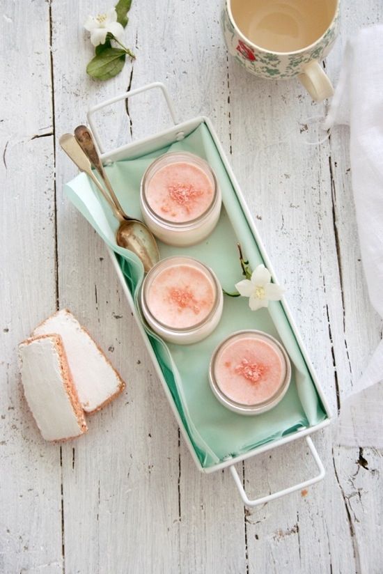 three desserts are sitting on a tray next to a cup of coffee and spoon