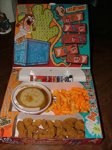 an open box filled with food on top of a wooden table