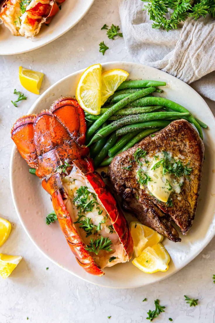 lobster, green beans and lemon wedges on a white plate with parsley garnish