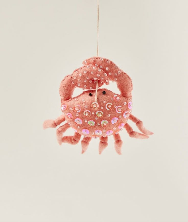 a pink crab ornament hanging from a string