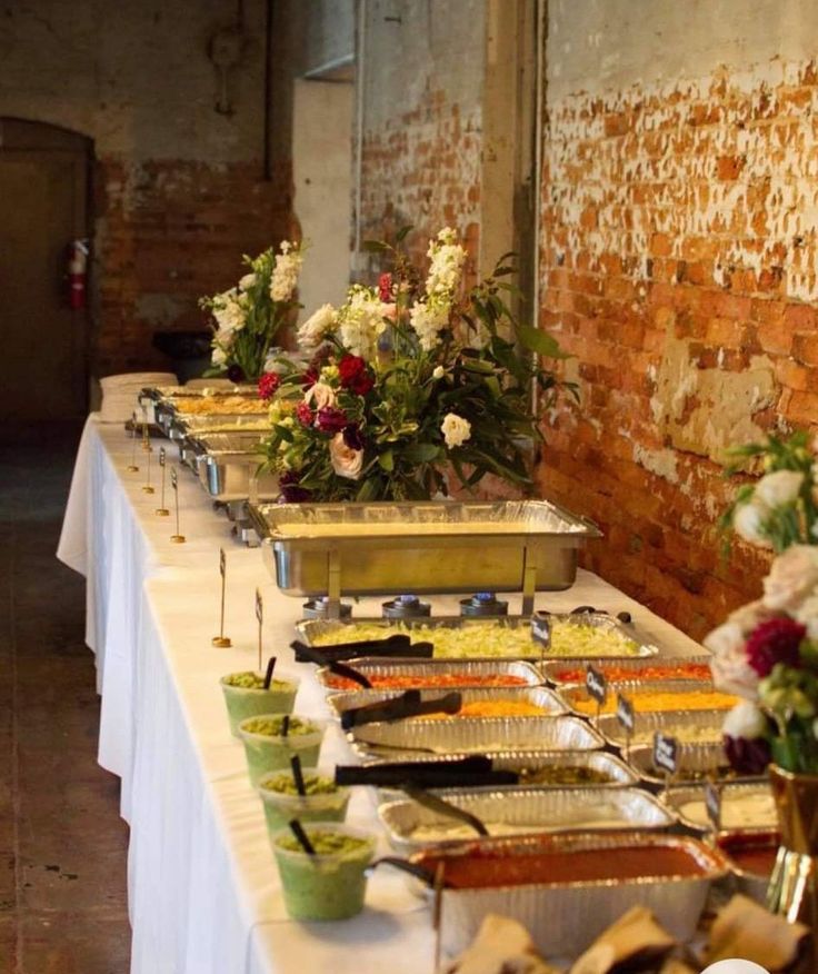 the buffet table is set up with many different types of food and flowers on it