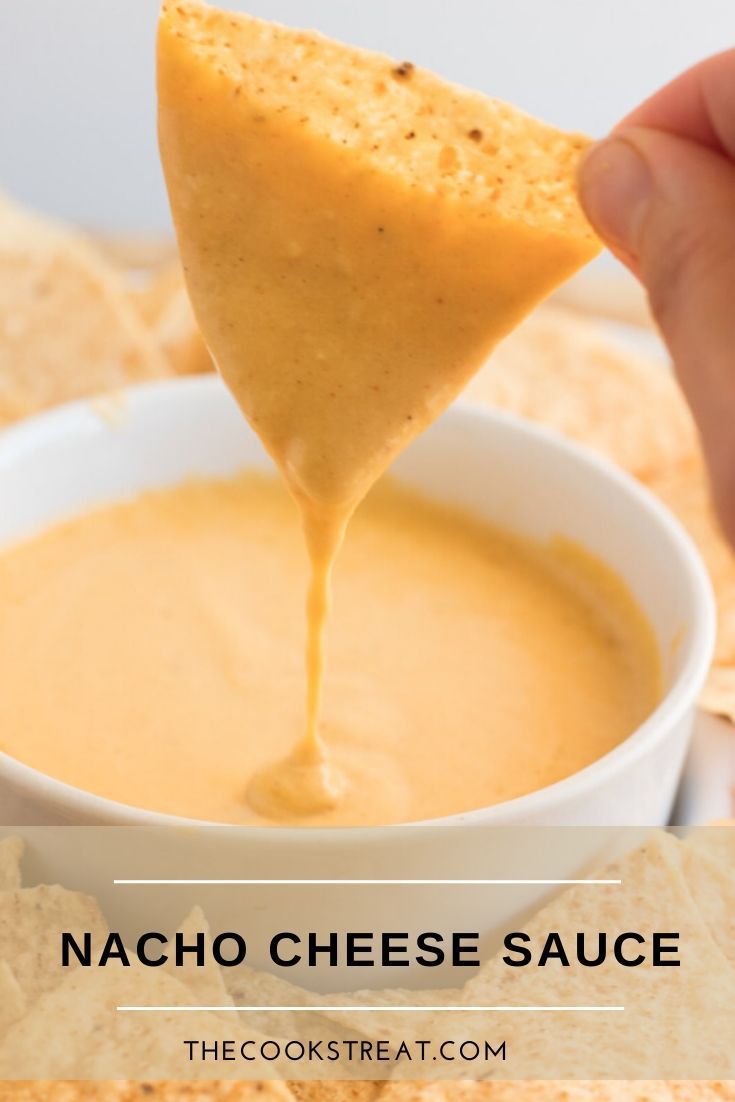 a tortilla chip being dipped into a bowl of quesadilla dip