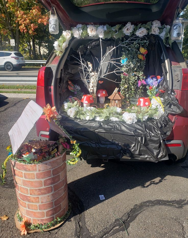 the trunk of a car is decorated with flowers and other things to be seen in it