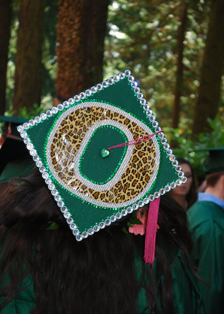 a graduation cap with the letter d on it in front of some trees and people