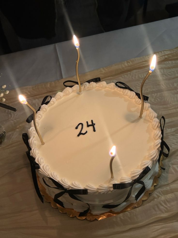 a birthday cake with candles on it and the number twenty four written in white frosting