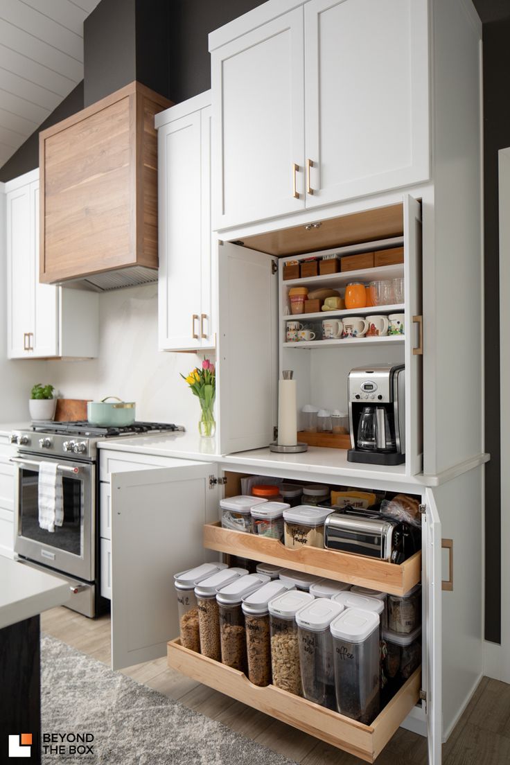 This kitchen remodel contains a built-in, organizational cabinetry with a hidden coffee station and white cabinetry. Pantry With Coffee Bar And Microwave, Kitchen Design With Coffee Station, Kitchen Coffee Station Next To Fridge, Kitchen Built In Organization, Kitchen With Hidden Coffee Station, Built In Kitchen Ideas, Coffee Built In Kitchen, Coffee Station Next To Fridge, Built In Recycling Bins Kitchen