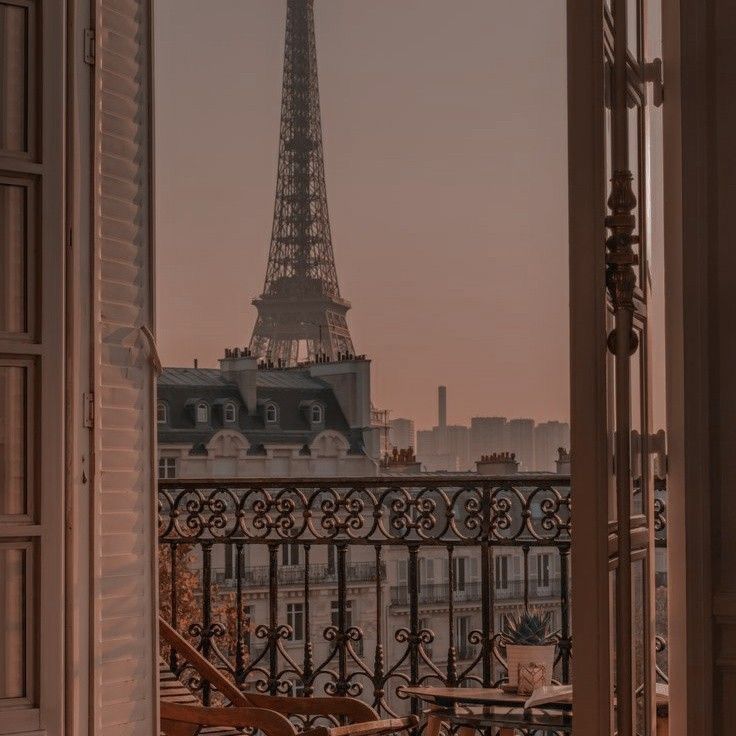 the eiffel tower is seen through an open door in front of a balcony