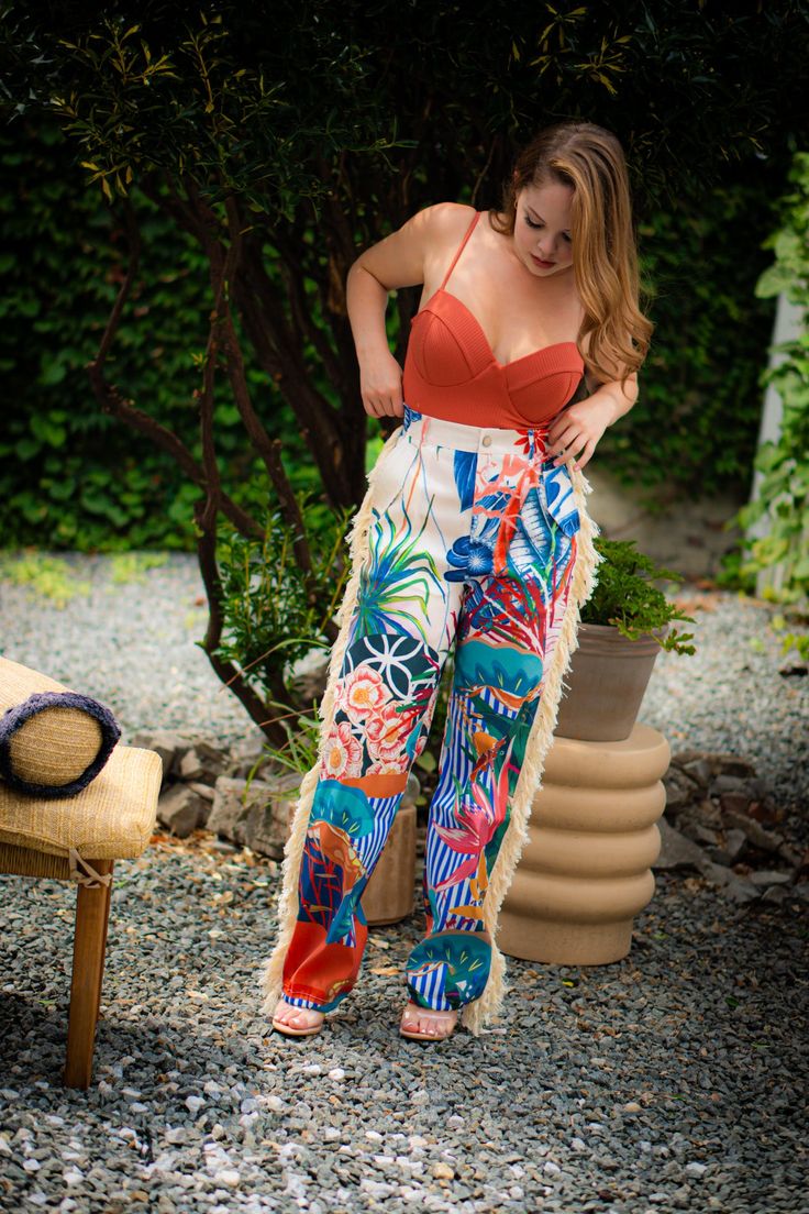 Look like paradise with our ISLAND GAL | FRINGE PANTS. Featuring a tropical print with fringe accents, these super sexy pants will make a bold statement with their vibrant colors and eye-catching prints. Embrace your inner island goddess and turn heads wherever you go! DETAILS & FIT Non-stretch pants High-waisted Elastic waistband Pockets Flared Cuffed ankles CONTENTS & CARE Inseam is 30 inches 90% Polyester 10% Spandex Hand wash cold Do Not Dry Summer Beach Pants With Tropical Print, High Waist Tropical Bottoms For Beach Party, Tropical High-waist Bottoms For Beach Party, Tropical Wide Leg Pants With Tropical Print, Summer Pants With Tropical Print For Beach Season, Tropical Wide Leg Pants For Beach Season, Wide Leg Tropical Print Pants For Beach Season, Vibrant Print Beach Bottoms For Vacation, Vibrant Print Bottoms For Vacation Beach Season