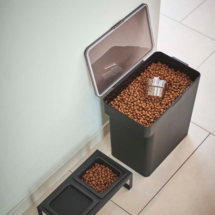 a dog food dispenser is shown next to a black box filled with coffee beans