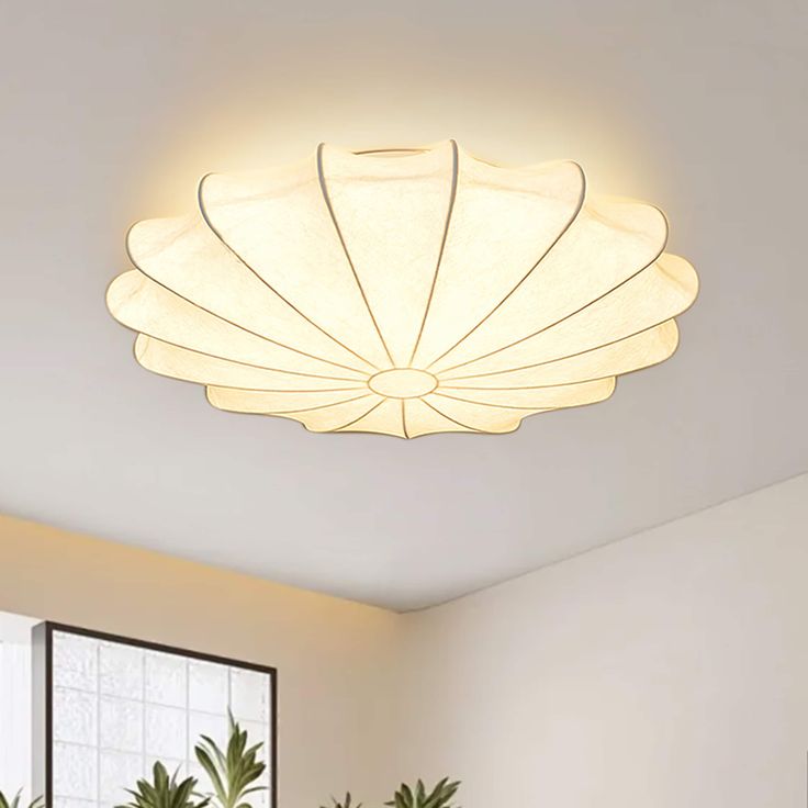 a living room with potted plants and a ceiling light