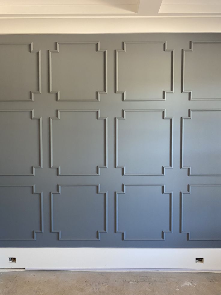 an empty room with gray walls and white trim