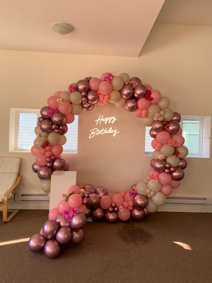 the balloon arch is decorated with pink and silver balloons