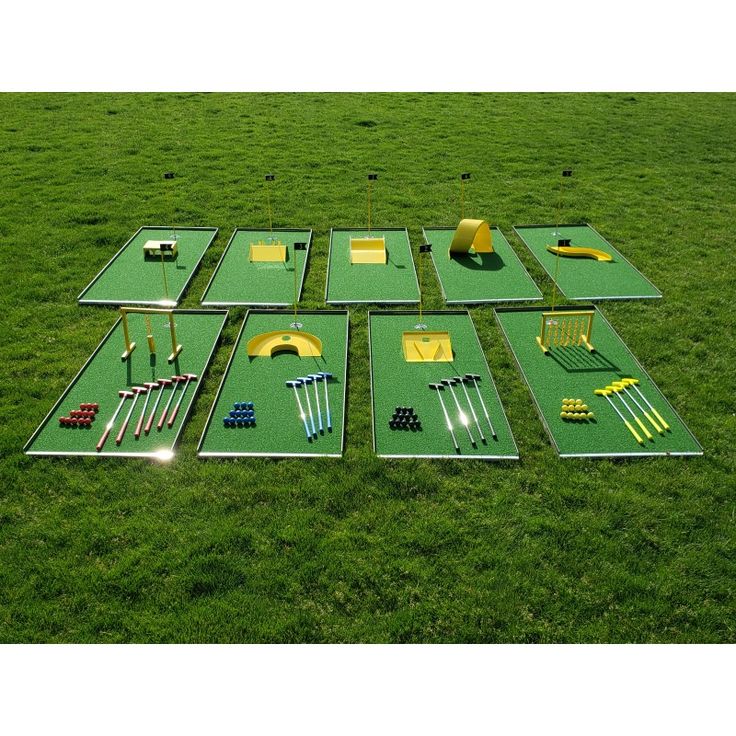 several pieces of golf equipment laid out in the grass on top of a green field