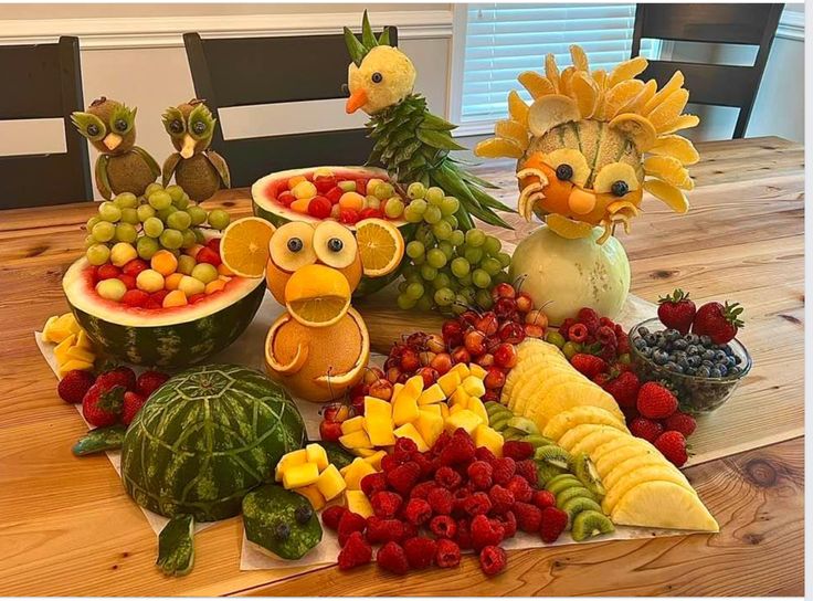 a table topped with lots of fruits and vegetables on top of a wooden table covered in birds