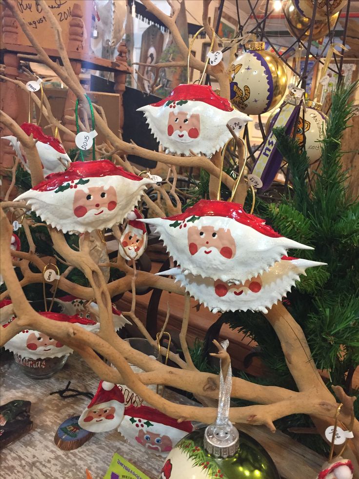 christmas decorations on display in a store with deer antlers and santa claus hats hanging from the branches