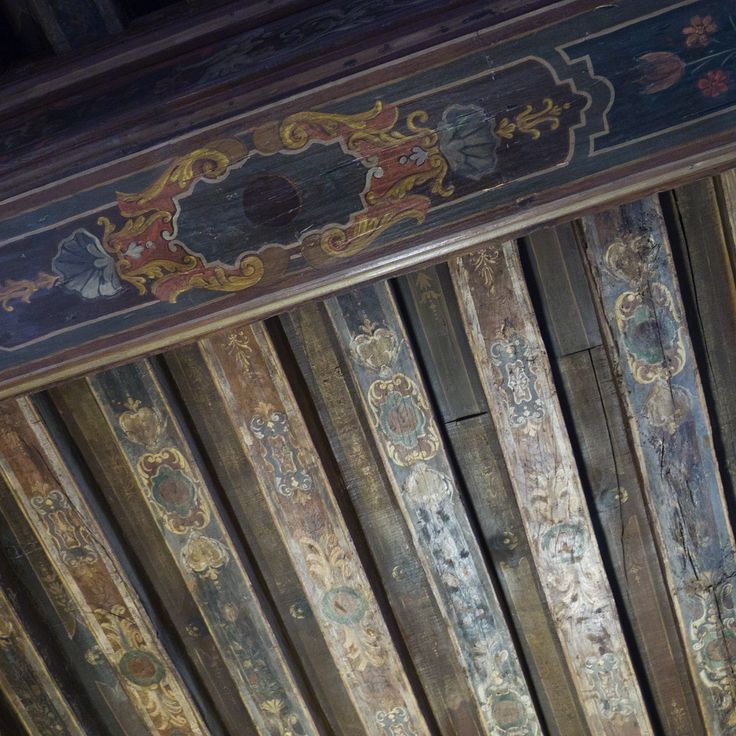 an old wooden ceiling with painted designs on it