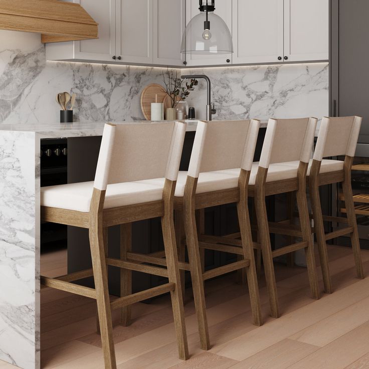 a kitchen with marble counter tops and wooden chairs