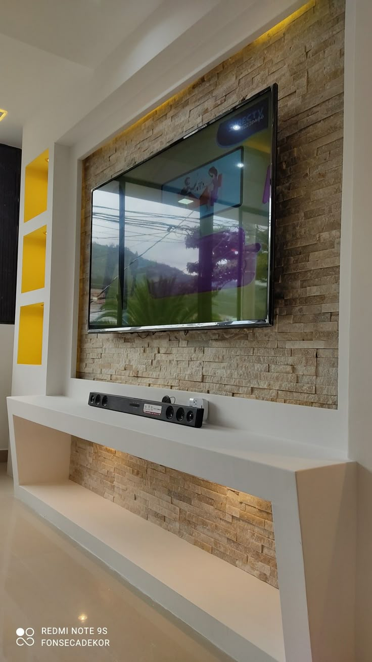 a flat screen tv mounted to the side of a wall in a modern living room