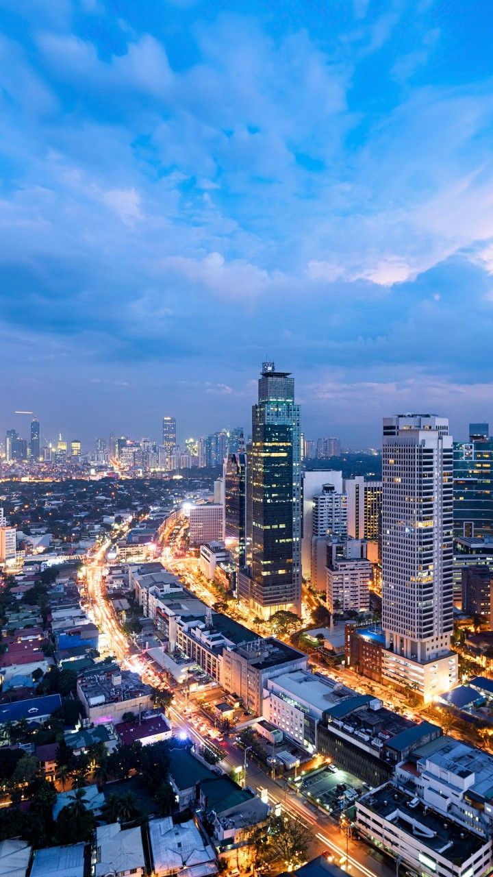 an aerial view of a city at night with lots of tall buildings and street lights