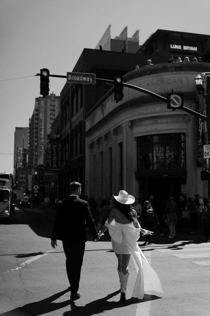 a man and woman are walking across the street