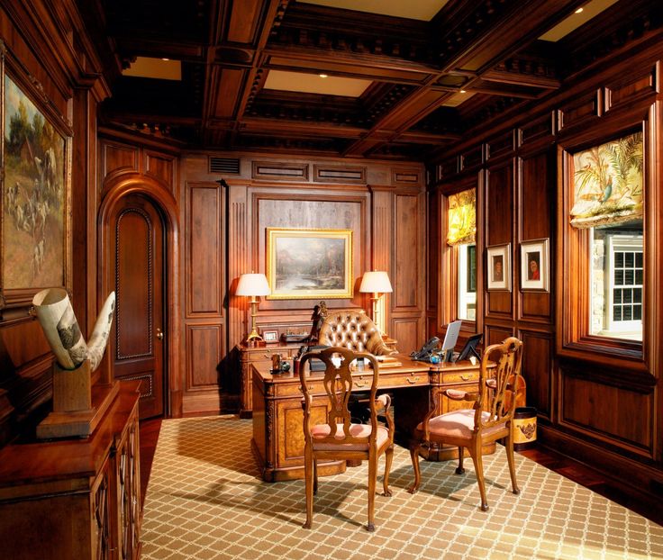 a room with wood paneling and furniture in the center is decorated with paintings on the walls