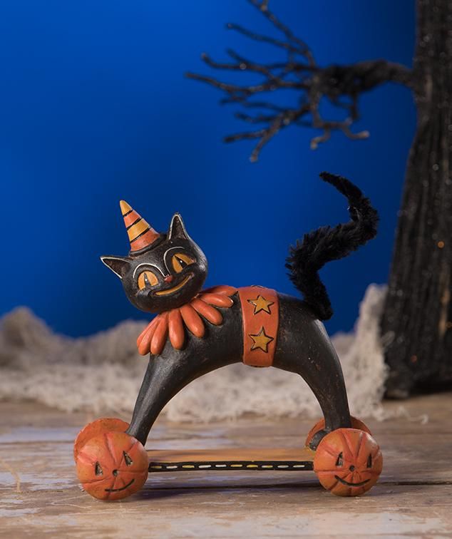 a black cat figurine on top of a skateboard