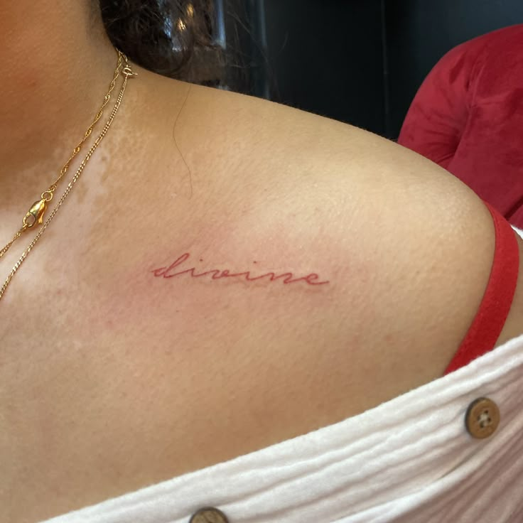 a woman's chest with the word divine written in cursive writing on it