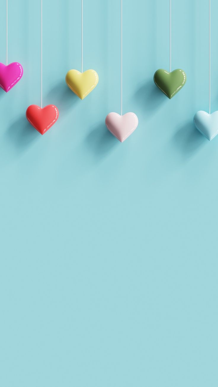 four hearts hanging from strings against a blue background