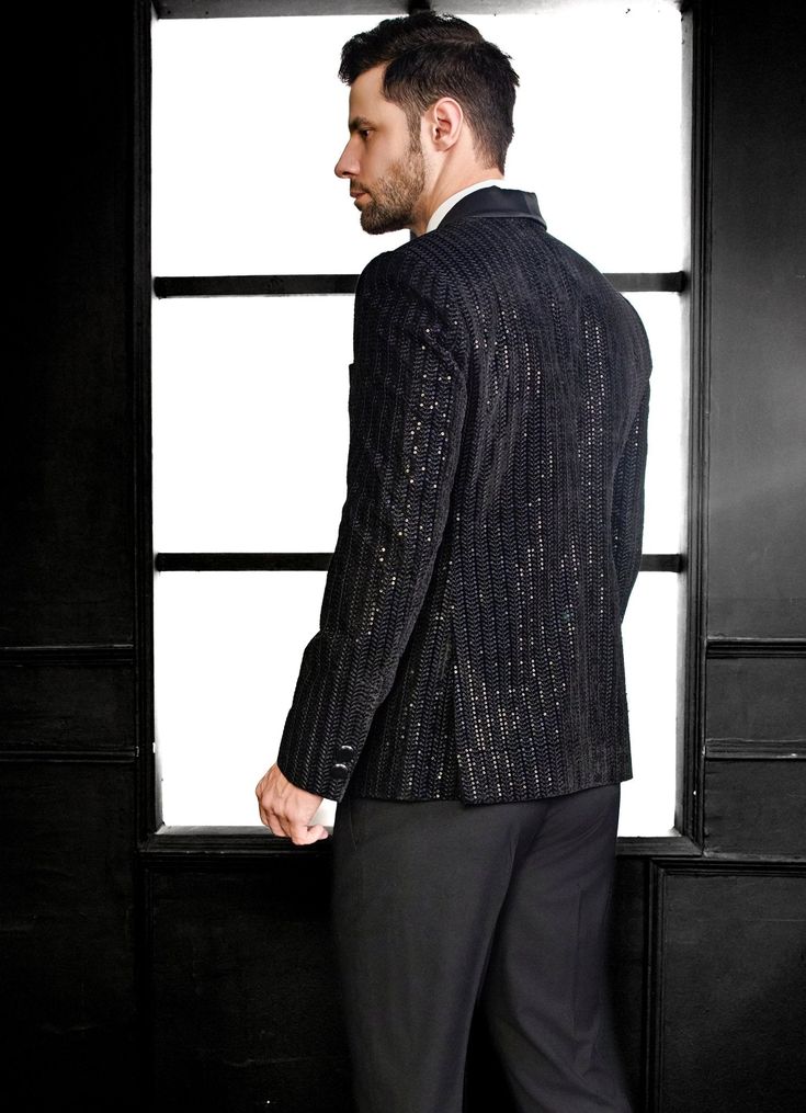 Elevate your formal wardrobe with the exquisite Black Embroidery Velvet Tuxedo Set, a perfect blend of classic elegance and modern flair. Crafted from luxurious velvet, this black jacket showcases intricate thread embroidery and shimmering sequins in a refined herringbone pattern, adding both texture and a subtle shine. Paired with matching black trousers, this ensemble offers a polished and sophisticated look. Ideal for wedding receptions, cocktail events, or sangeet nights, this tuxedo is designed for the discerning gentleman who values both style and comfort. Composition : Jacket, Pant - Velvet Care: Dry Clean Only and Vacuum Storage Delivery : 4-6 weeks as the product is hand crafted. Check Size Guide or choose MySize for free customisation (All Sizes above XL can be made at 15% additi Luxury Velvet Outerwear For Party, Black Formal Outerwear For Holidays, Elegant Black Suits For Holiday Season, Formal Black Holiday Outerwear, Elegant Fitted Outerwear For Festive Occasions, Elegant Embroidered Blazer For Party, Elegant Black Holiday Suit, Elegant Sequin Blazer For Festive Occasions, Luxury Black Embellished Blazer