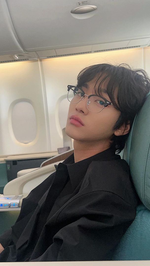 a man sitting in an airplane seat with his head resting on the armrests