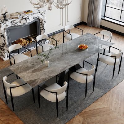 a dining room table and chairs with a fireplace in the background