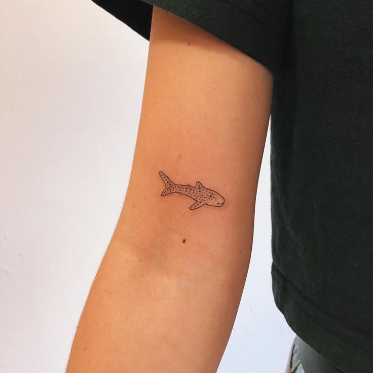 a person with a small tattoo on their arm that has an airplane drawn on it