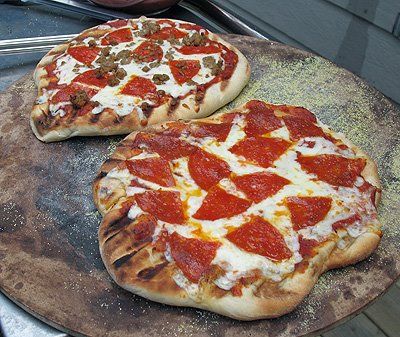 two pepperoni pizzas sitting on top of an oven