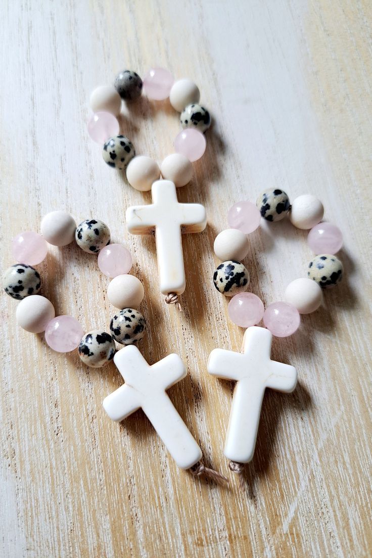 Beautiful handmade rosaries for your special religious occassion  Each rosary is made using a combination of 8mm gemstone beads on nylon thread and featuring a 20m x 30mm cream howlite cross.  The beads featured are  Rose quartz Matte fossil jasper Dalmation jasper  If you don't see your quantity available please DM me and I will ad it for you.  These are approximately 3.5 inches Handmade Rosary With Round Beads As Gift, Spiritual Rosary Bracelet With Cross For First Communion, White Cross Rosary For Jewelry Making, Gift Rosary With 8mm Beads And Cross Shape, Beaded Cross Rosary Bracelet For Gift, Gift Beaded Cross Rosary Bracelet, Beaded Cross Rosary Bracelet Gift, Spiritual Cross Rosary Bracelet For Baptism, White Cross Rosary Bracelet As Gift