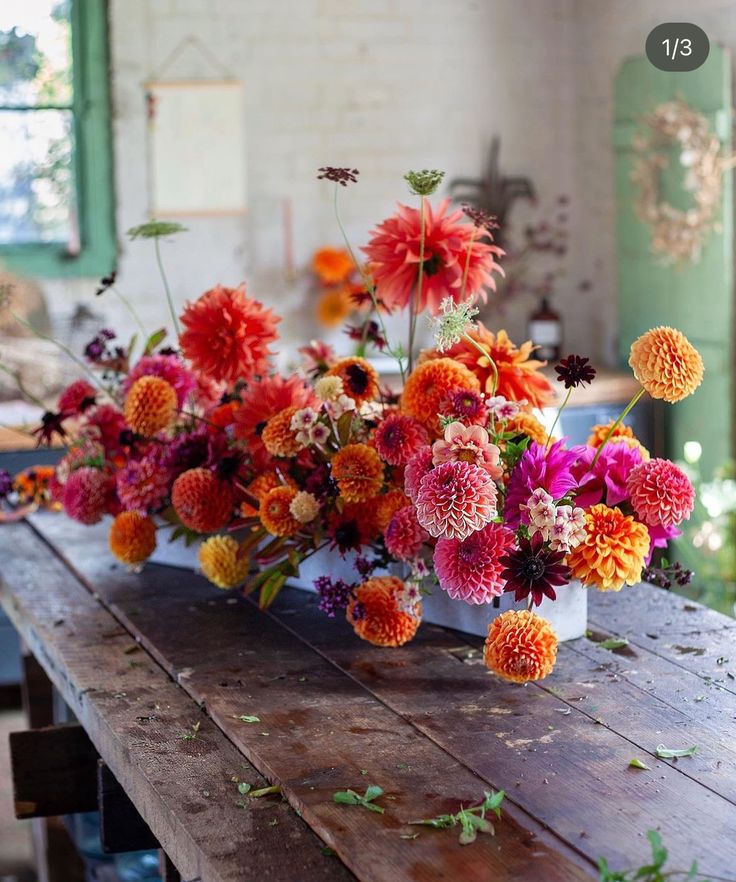 an arrangement of colorful flowers on a wooden table