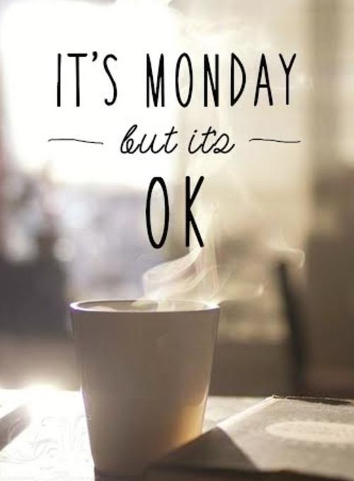 a coffee cup sitting on top of a table with the words it's monday but it's ok