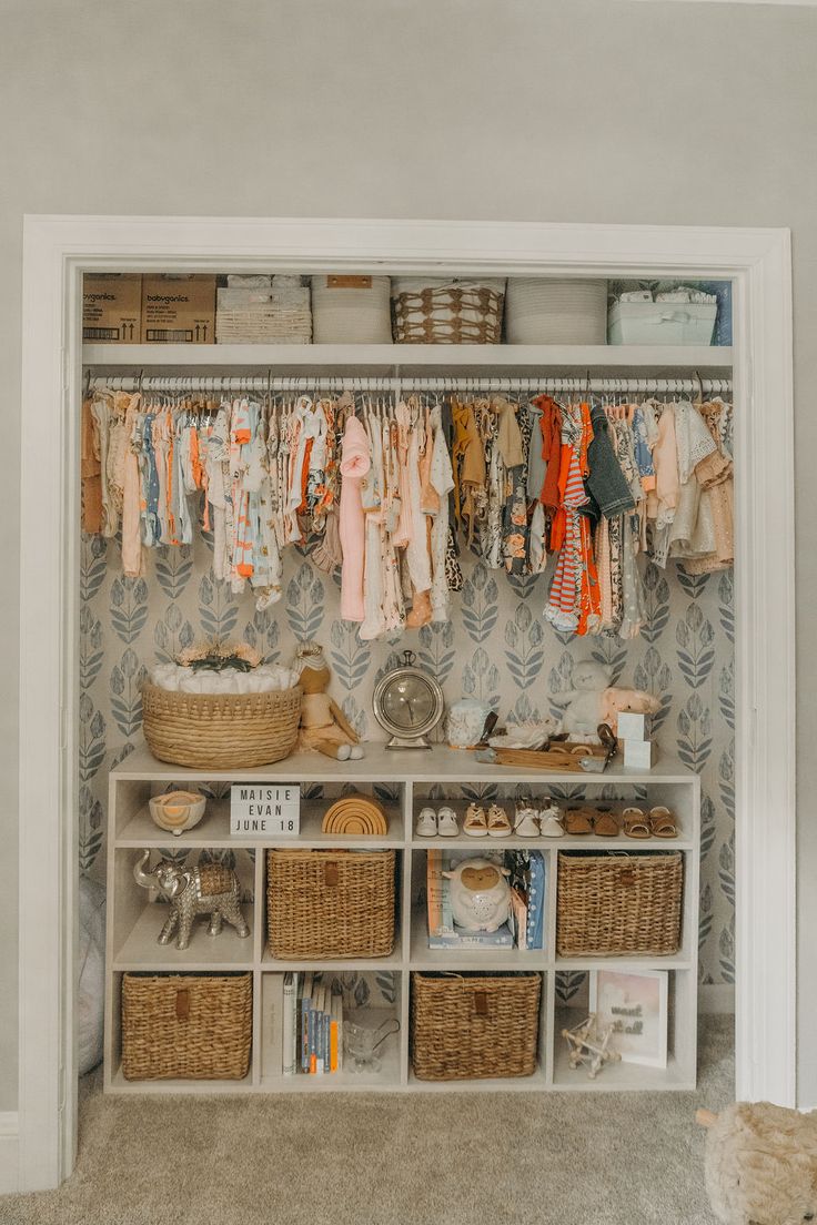 an organized closet with baskets and clothes hanging on the wall, next to a teddy bear